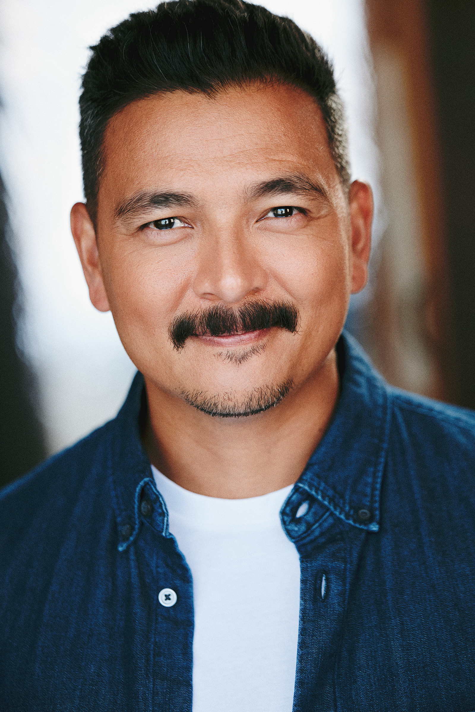headshot with soft smile and mustache